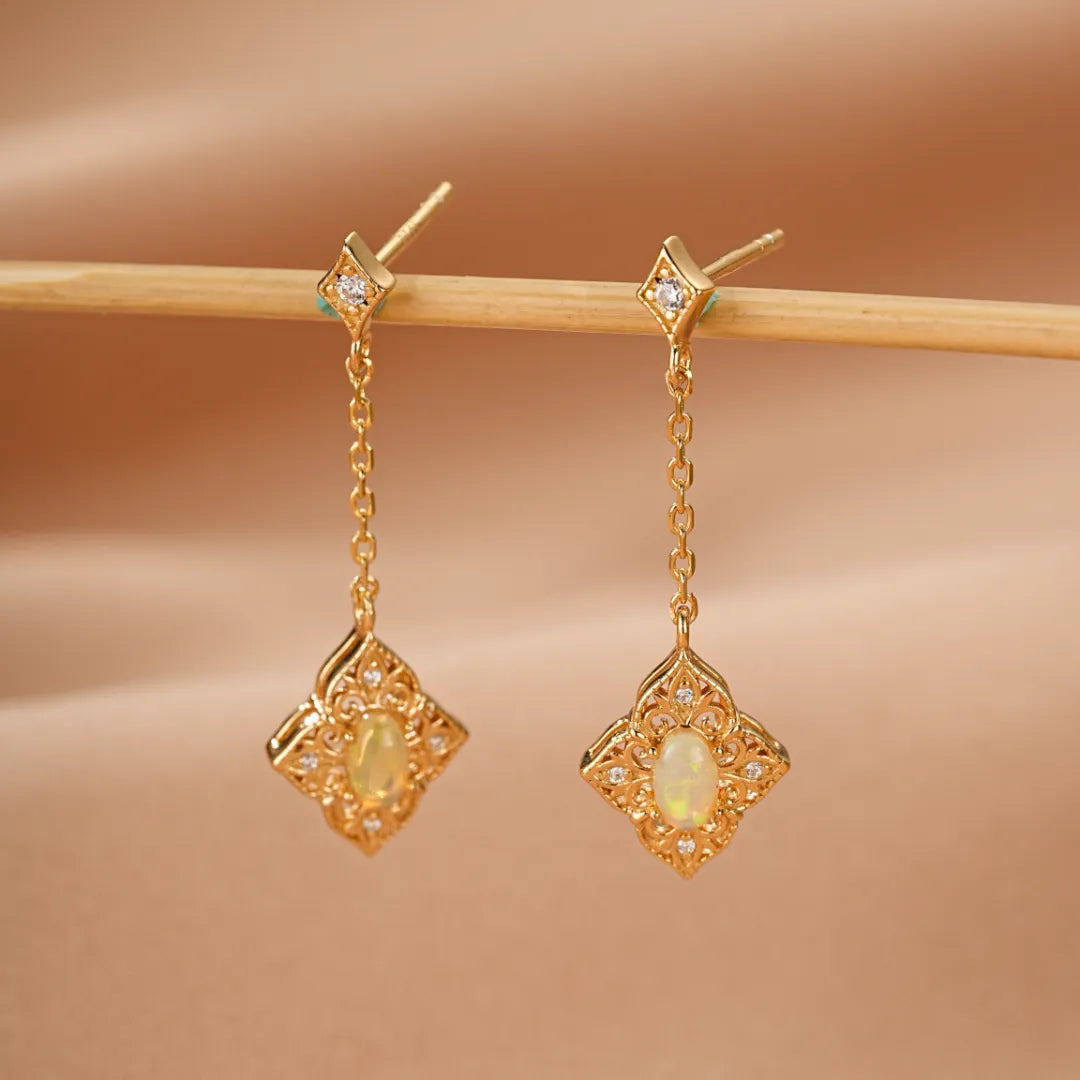 Boucles d'oreilles pendantes en argent doré or 10K ornées d'opales centrales et de diamants dans un design ajouré inspiré de l'antique.