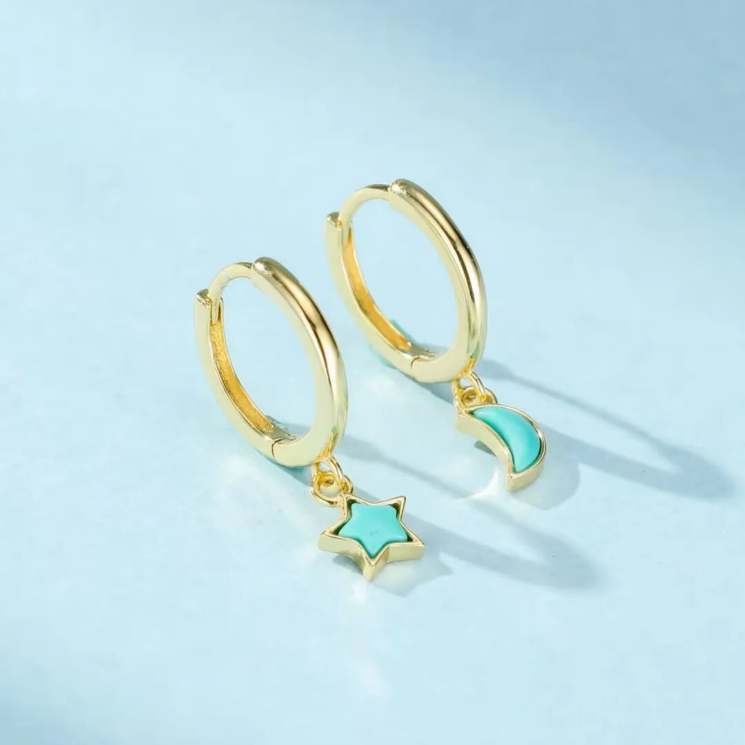Boucles d'oreilles créoles en argent doré ornées de turquoise, l'une avec un pendentif étoile et l'autre avec un croissant de lune.
