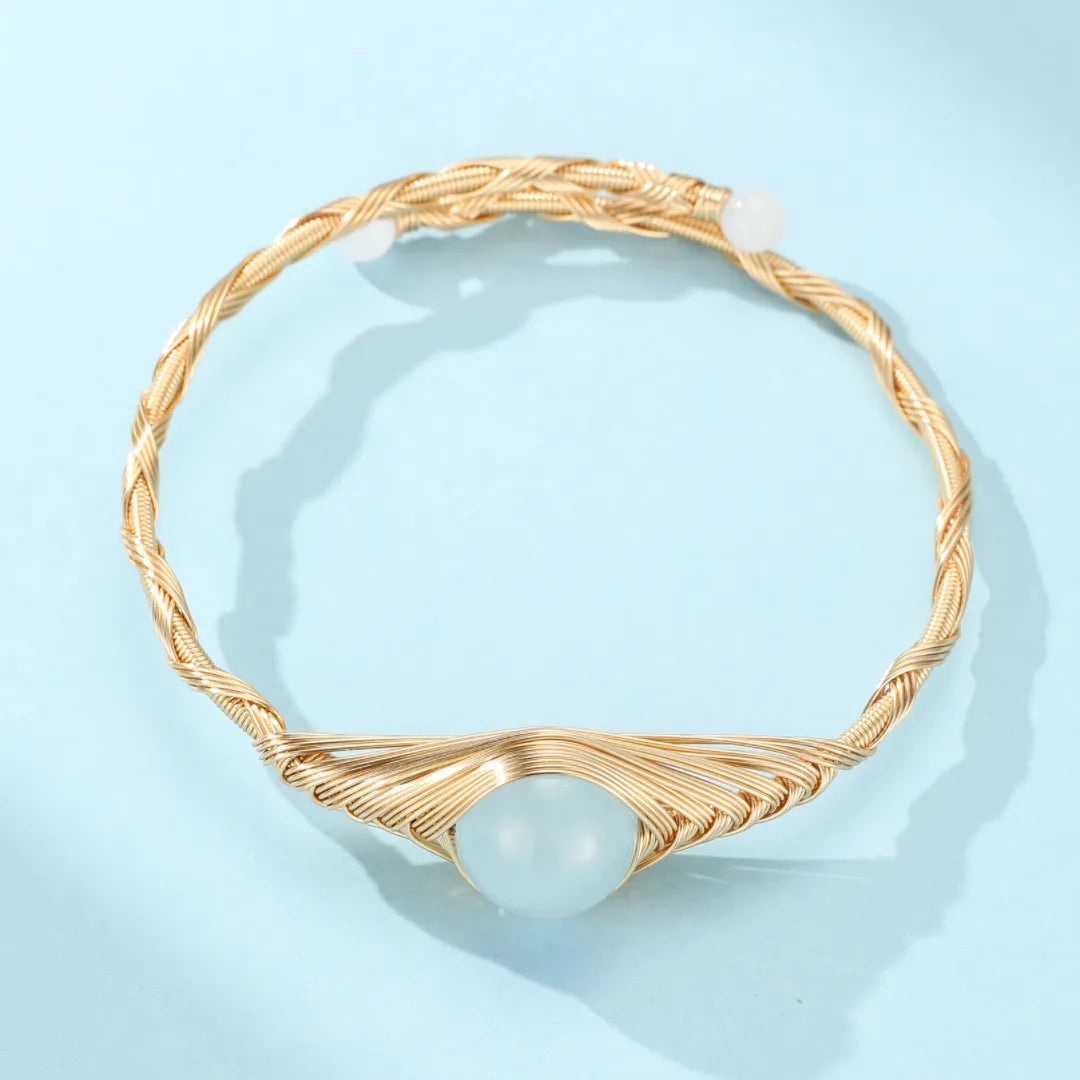Bracelet jonc doré or 14K "Puissance Marine" avec une pierre d'aigue-marine centrale et deux petites perles blanches de chaque côté.