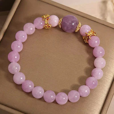 Bracelet "Reine de Douceur" en améthyste et perles roses, orné de détails dorés et de petites pierres rouges.