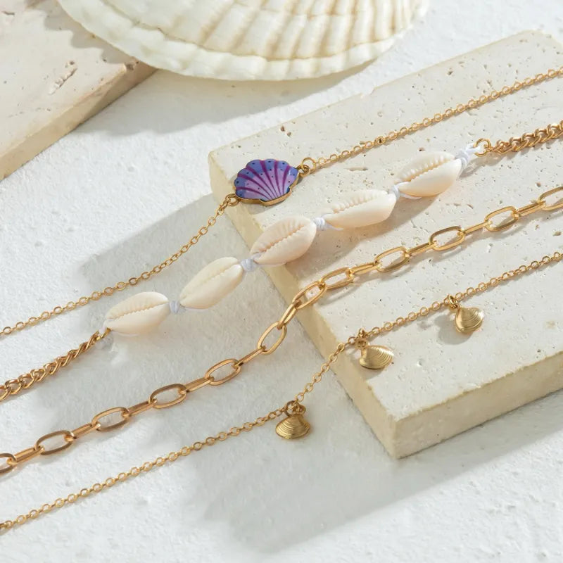 Ensemble de trois bracelets de cheville en or, ornés de coquillages naturels et d'un pendentif coquillage violet, parfaits pour un look estival.