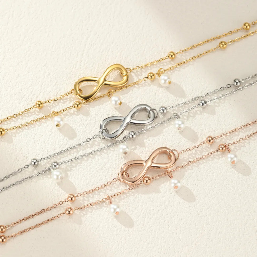 Trois bracelets de cheville en forme de symbole infini avec des perles nacrées, disponibles en or, argent et or rose.