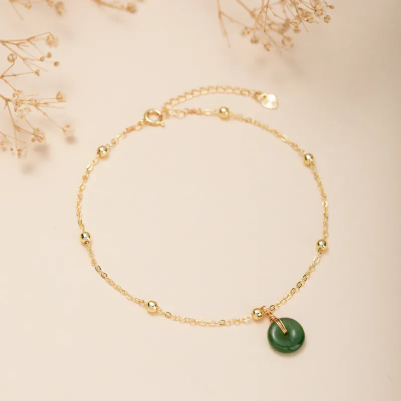 Bracelet de cheville "Vert Doux" en argent doré or, orné d'une petite médaille ronde en jade vert et de perles dorées sur une chaîne fine.