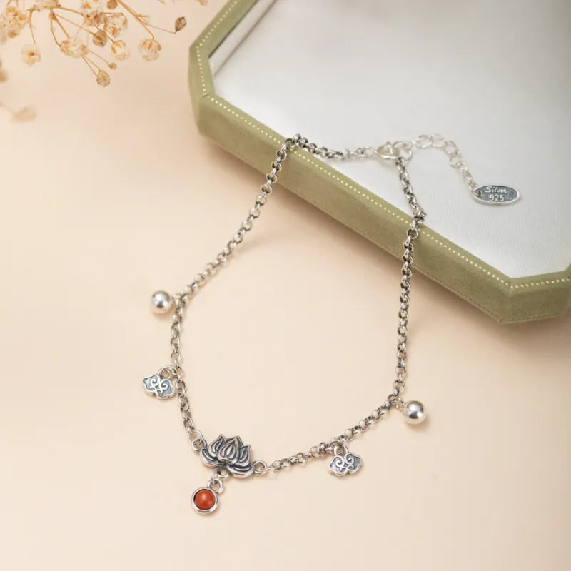 Bracelet de cheville en argent 925 orné d'un pendentif lotus, d'une agate orange et de petits nuages décoratifs.