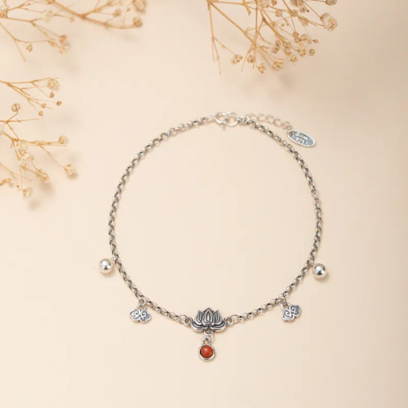 Bracelet de cheville en argent orné d'un pendentif lotus avec une agate rouge, de petites perles argentées et des breloques nuage.