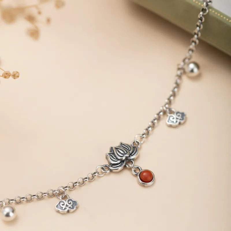 Bracelet de cheville en argent orné d'un lotus, d'une agate rouge et de breloques nuages.