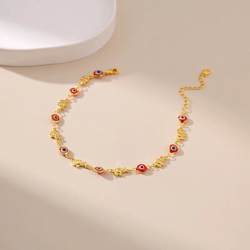 Bracelet de cheville doré or "Gardien Mystique" avec des breloques yeux bleus et rouges et des éléphants