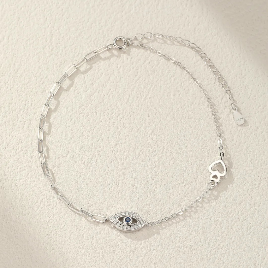 Bracelet de cheville "Protection Élégante" en argent 925 orné d'un œil bleu stylisé et de cœurs ajourés.