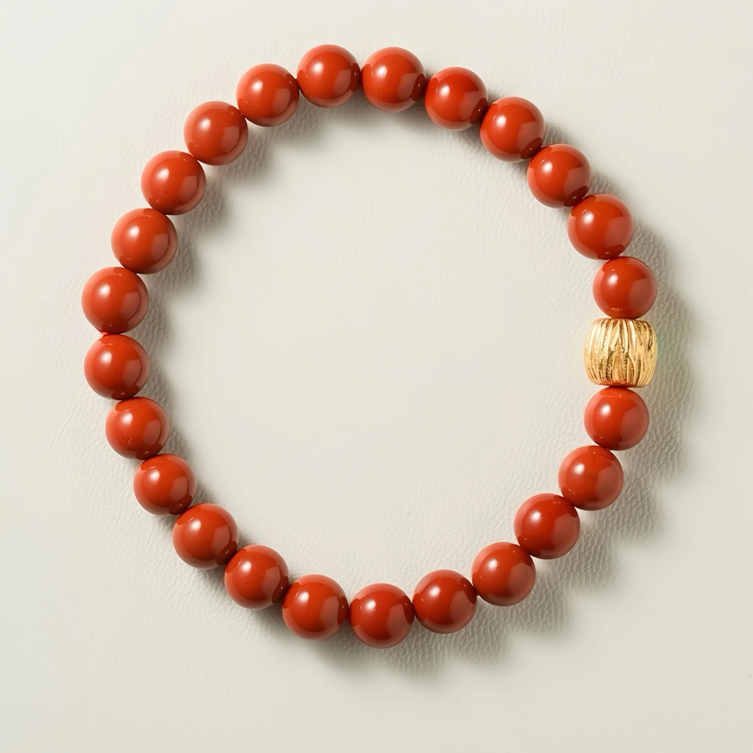 Bracelet artisanal en agate rouge naturelle avec fermoir en argent plaqué or, vue rapprochée sur fond blanc.