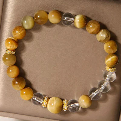 Bracelet "Énergie Vitale" en œil de tigre doré et cristal de roche transparent, avec des perles intercalaires dorées ornées de petits diamants.