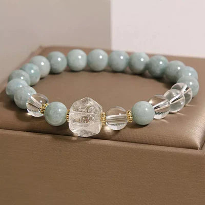 Bracelet "Clarté Apaisante" fait de perles rondes bleu pâle de jade et de cristaux de roche facetés, avec des perles intercalaires dorées.