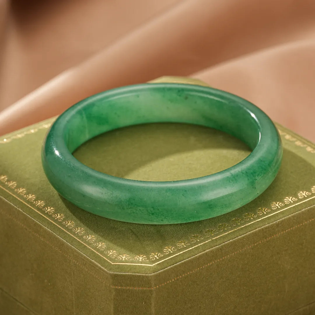 Bracelet jonc Aventurine "Énergie Vitale" vert, sur une boîte à bijoux verte.