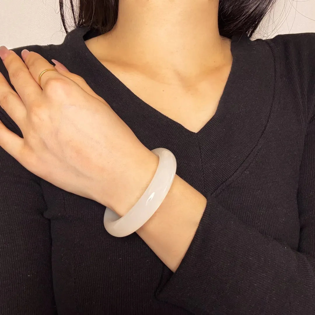 Bracelet jonc en jade blanc "Paix Intérieure" porté au poignet d'une femme.