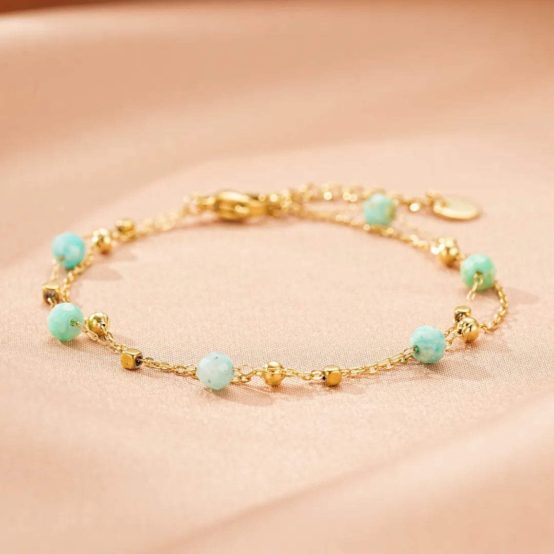 Bracelet fin en plaqué or avec des perles d'amazonite bleues claires et des petites perles dorées cubiques et rondes.