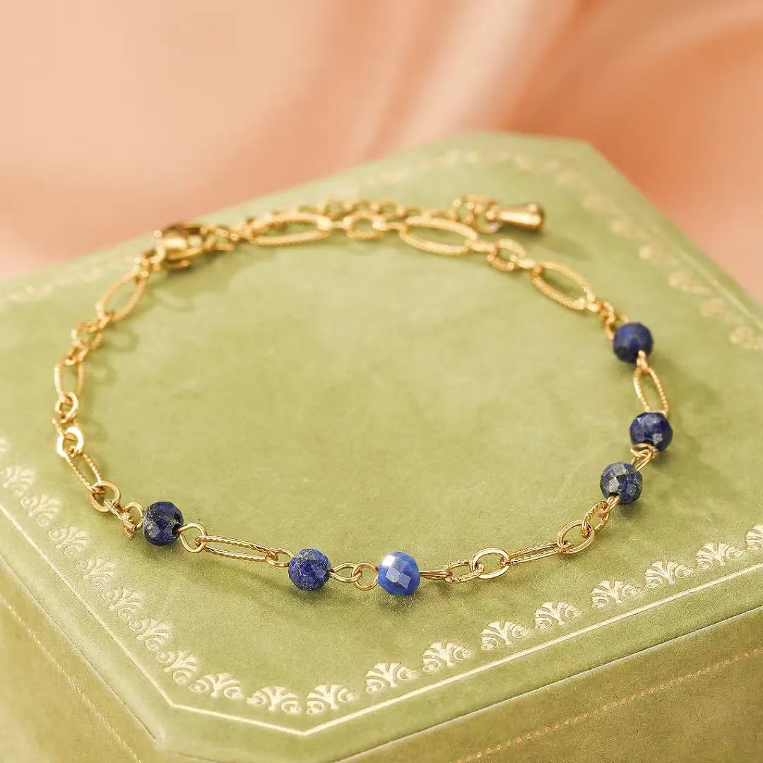 Bracelet en or avec des perles de lapis-lazuli facettées réparties le long de la chaîne.