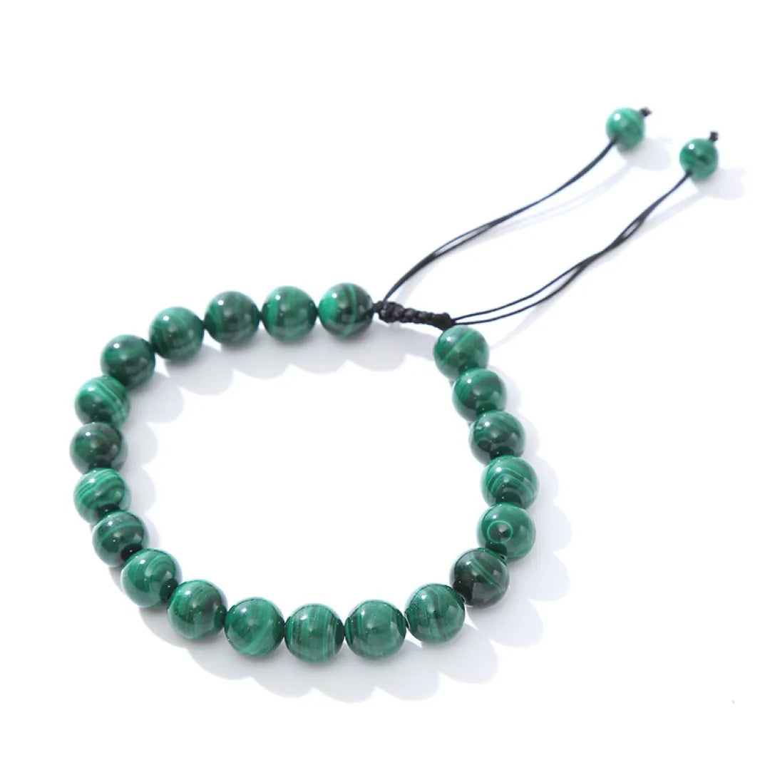 Bracelet "Harmonie Énergétique" fait de perles rondes de malachite verte avec des motifs naturels, reliées par un cordon noir réglable.