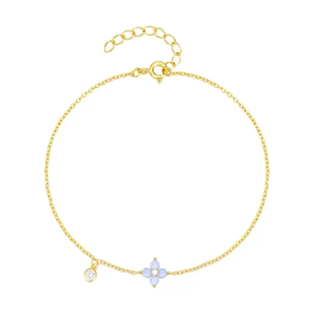 Bracelet fin en argent doré à l'or, orné d'une petite fleur en opale bleue et d'un cristal scintillant.