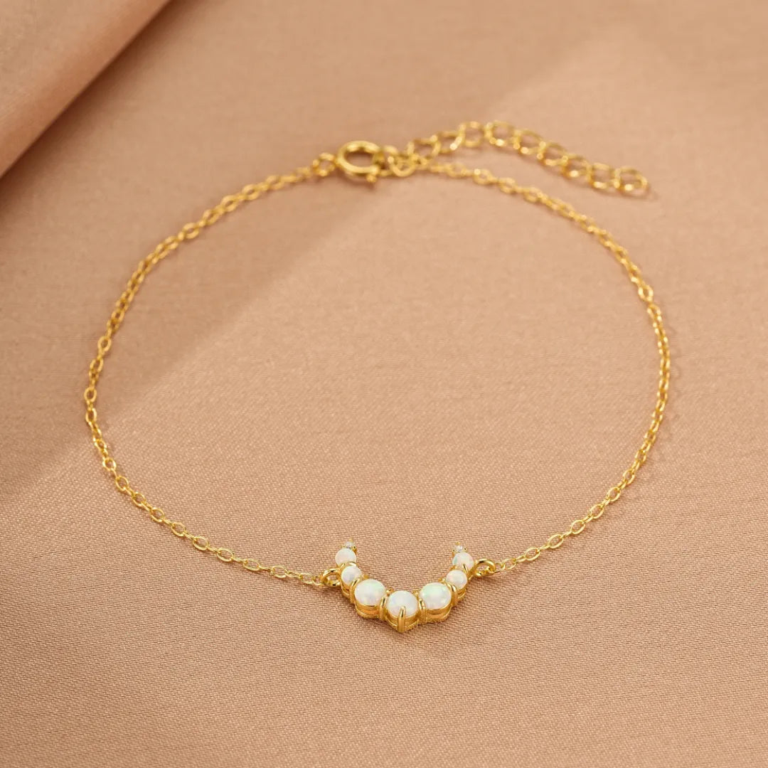 Bracelet en argent doré 18 carats avec des opales disposées en demi-lune, nom "Lune Douce".
