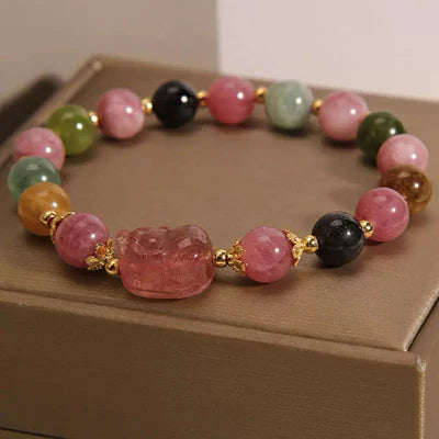 Bracelet Pi Xiu en quartz fraise et tourmaline avec des perles multicolores et des ornements dorés.