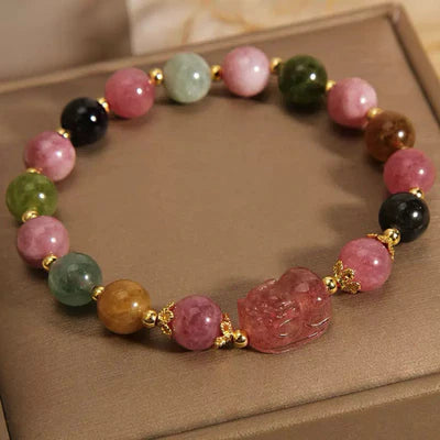 Bracelet Pi Xiu en tourmaline et quartz fraise avec des perles multicolores et des détails dorés.