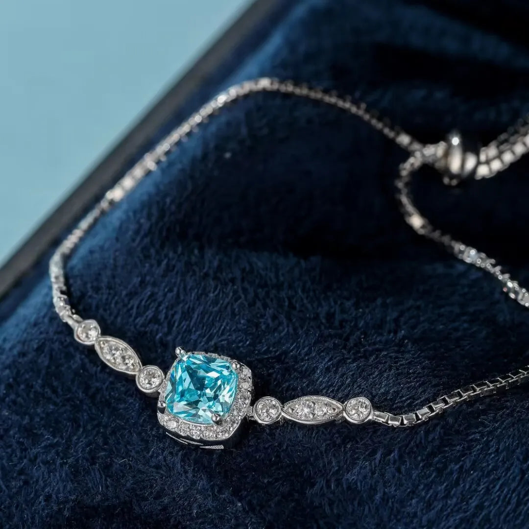 Bracelet en argent 925 avec une topaze bleue carrée entourée de petits cristaux et une chaîne délicate.