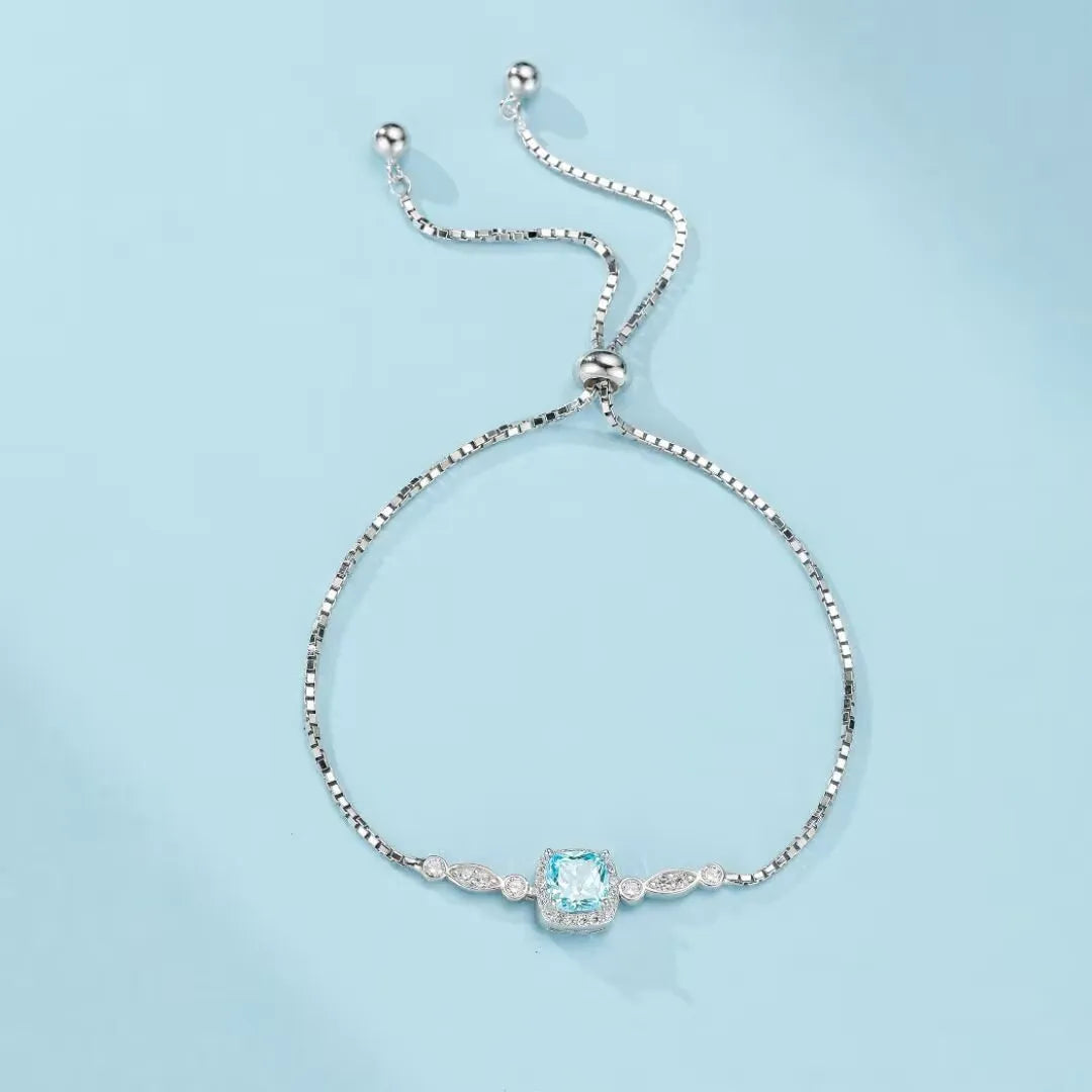 Bracelet jonc "Magie Océanique" en argent 925 avec une topaze bleue carrée centrale et des petits diamants incrustés sur les côtés.