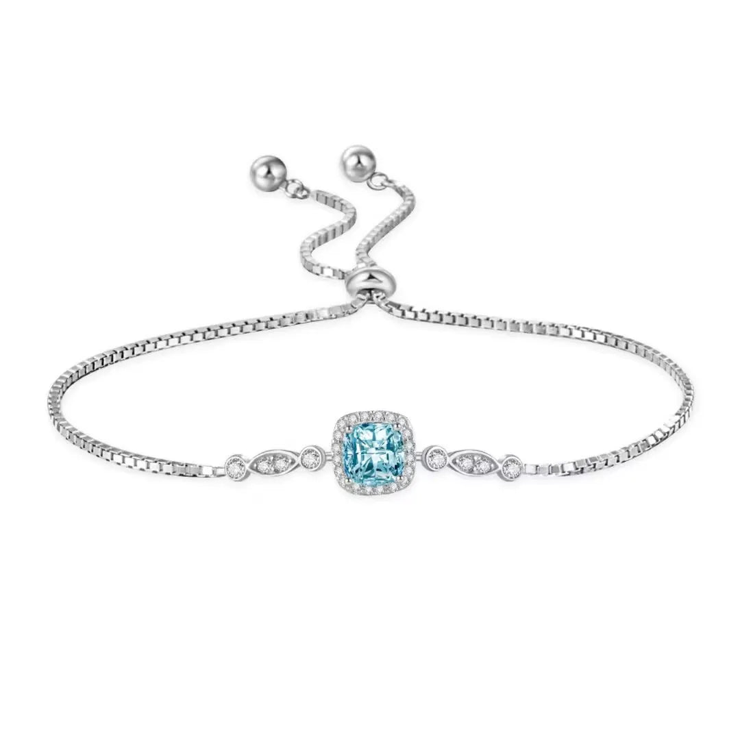 Bracelet jonc réglable en argent 925 avec une topaze bleue centrale carrée entourée de petits diamants sertis et une chaîne à maille forçat.