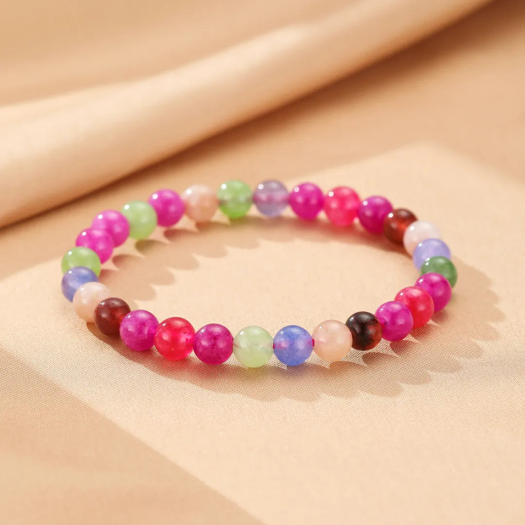 Bracelet en tourmaline multicolore "Équilibre Coloré" avec des perles rondes de différentes couleurs vives comme le rose, le vert, le violet, le bleu, et le blanc.