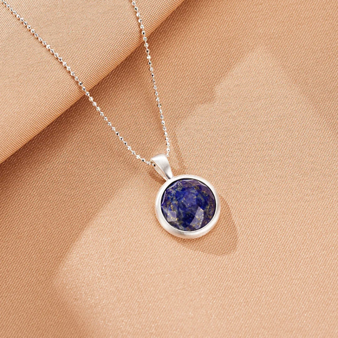 Collier en argent avec un pendentif rond en Lapis Lazuli facetté, le nom du collier est "Profondeur Céleste".