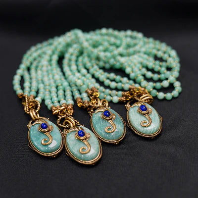 Collier Amazonite "Voyage Marin" avec plusieurs rangées de perles vert d'eau et pendentifs ovales en amazonite sertis d'une petite pierre bleue.