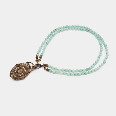 Collier double rang en amazonites bleues pâles avec un pendentif ovale ouvragé couleur bronze.