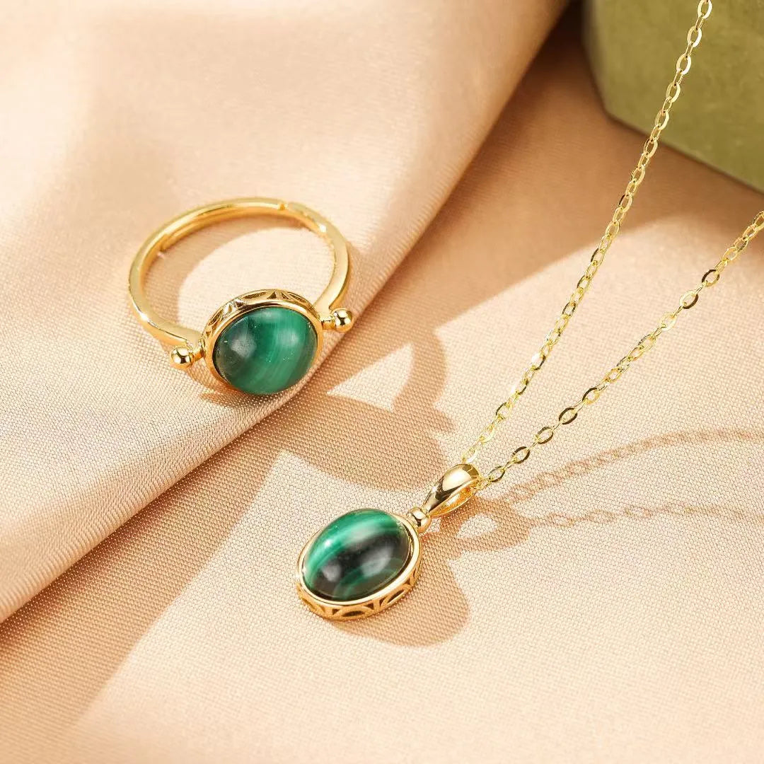 Ensemble de bijoux "Aura Antique" en argent doré, composé d'un collier avec un pendentif en malachite ovale et d'une bague assortie avec une pierre de malachite centrale.