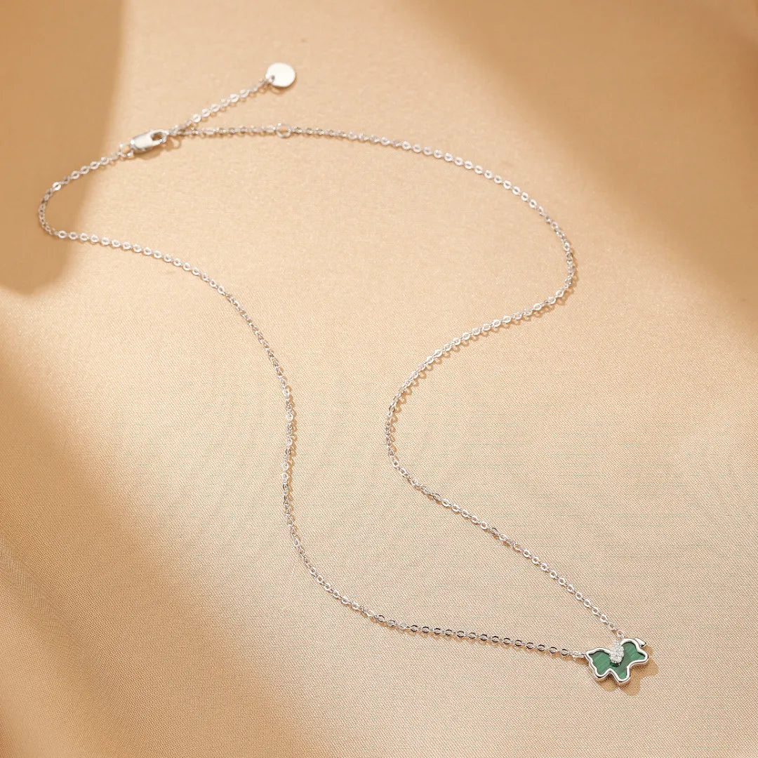 Collier en argent avec un pendentif en forme de cheval stylisé en malachite verte, le collier est réglable et présente une petite breloque ronde près du fermoir.
