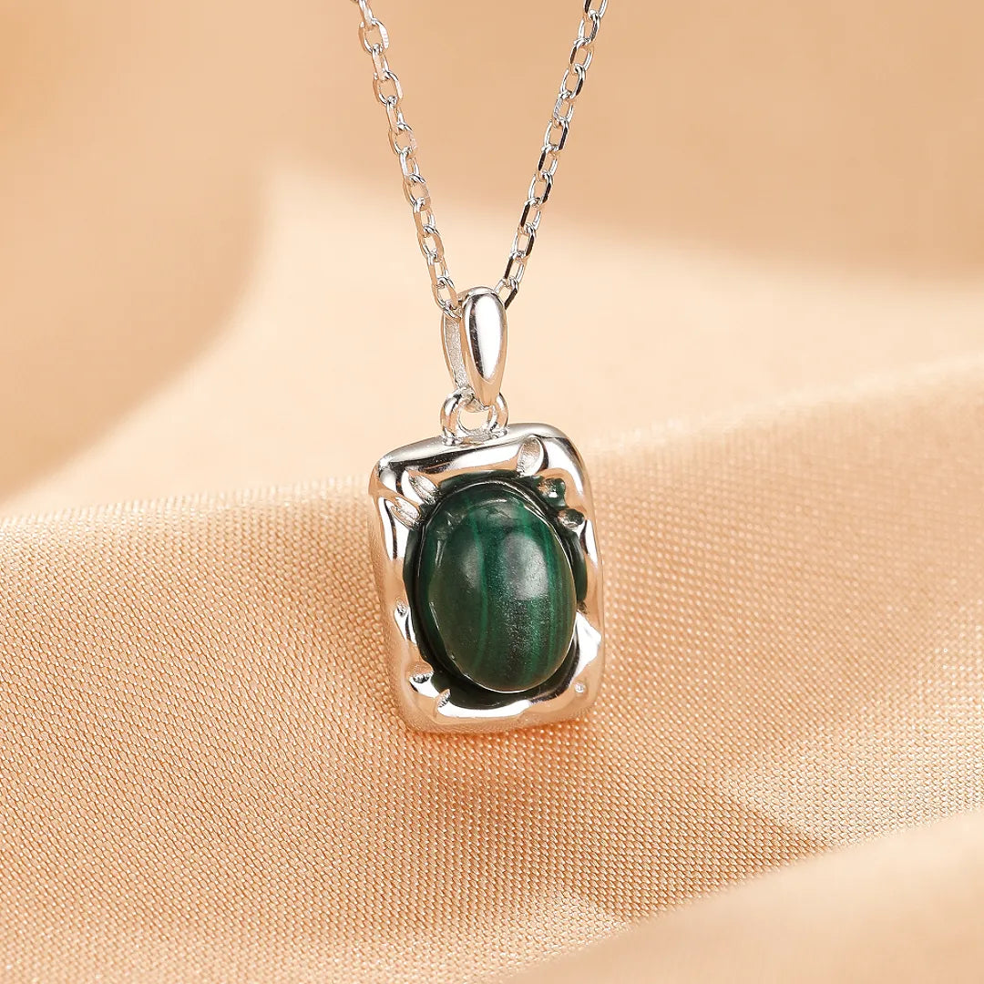 Collier argent avec un pendentif rectangulaire texturé serti d'une pierre de malachite verte naturelle au centre.
