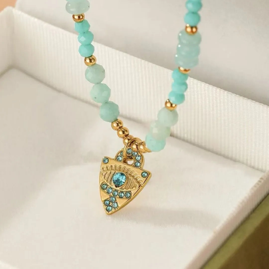 Collier "Œil Apaisant" en amazonite et pendentif doré en forme d'œil bleu serti de strass.