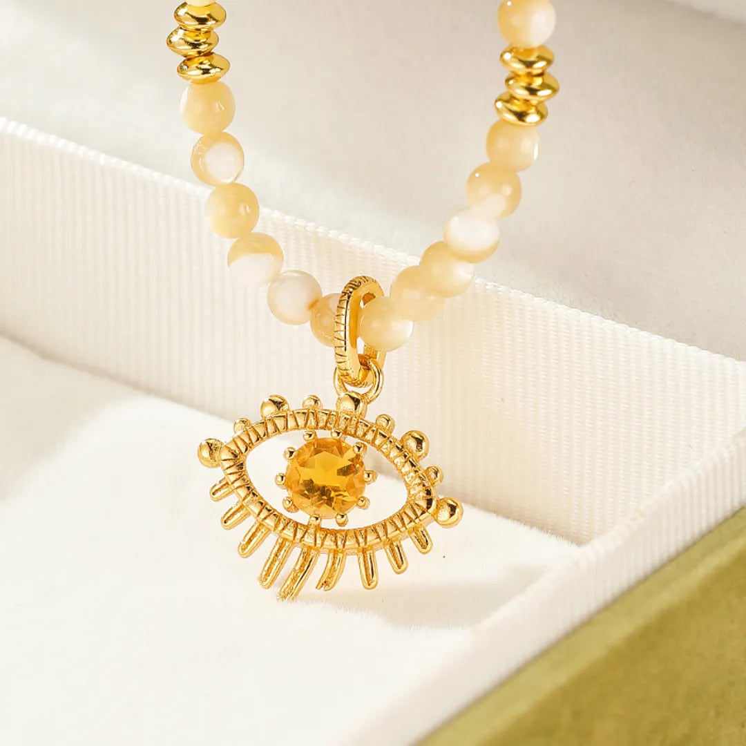 Collier œil de protection en argent doré or avec une pierre de citrine jaune au centre et des perles nacrées claires