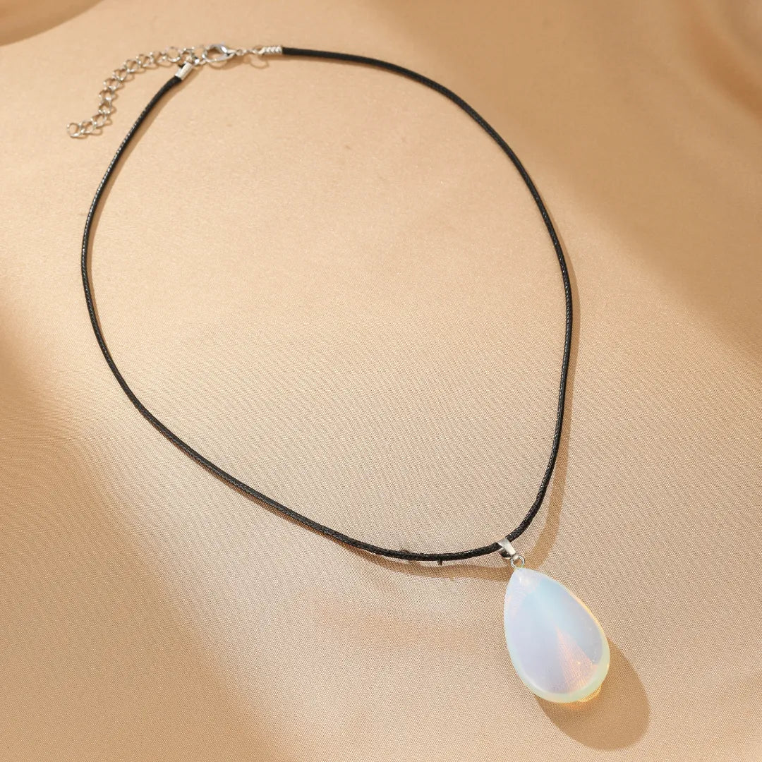 Collier avec pendentif opale en forme de gouttelette, monté sur un cordon noir réglable.
