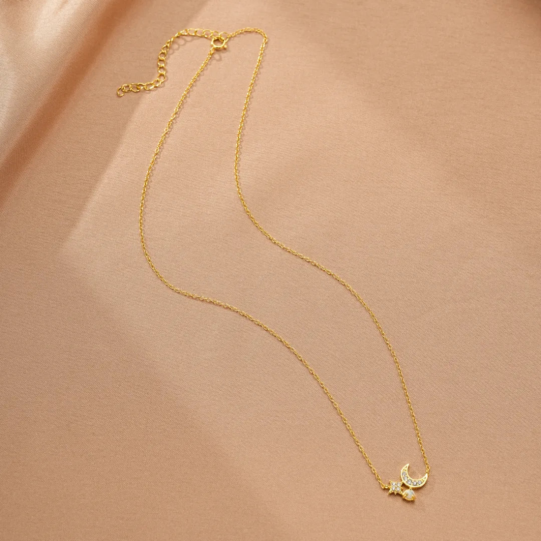 Collier fin en argent doré à l'or 18 carats avec un pendentif en croissant de lune orné de zirconiums et une petite étoile scintillante.