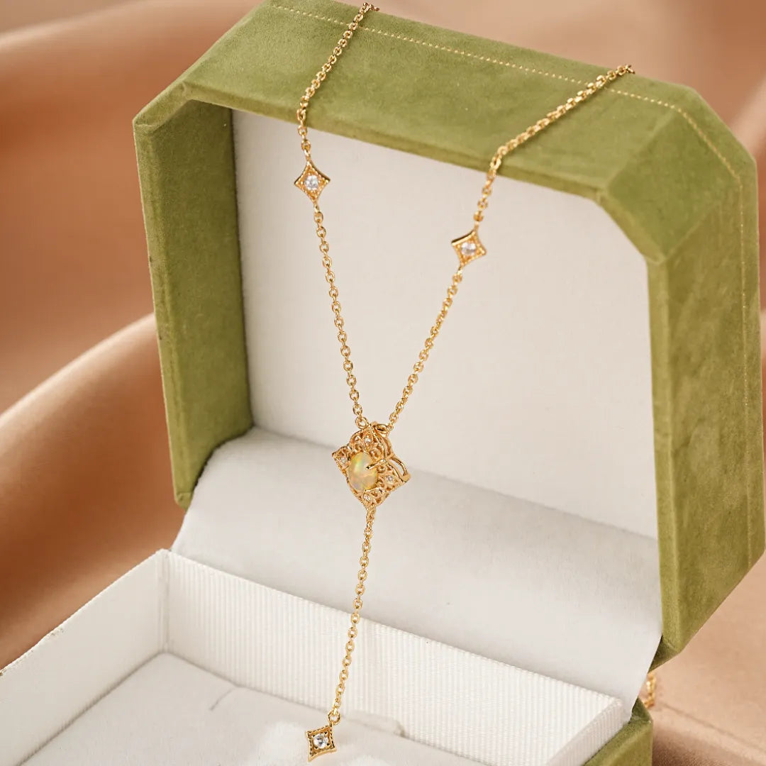 Collier "Lumière Antique" en argent doré or 10k avec une opale centrale et des diamants en forme de losange.