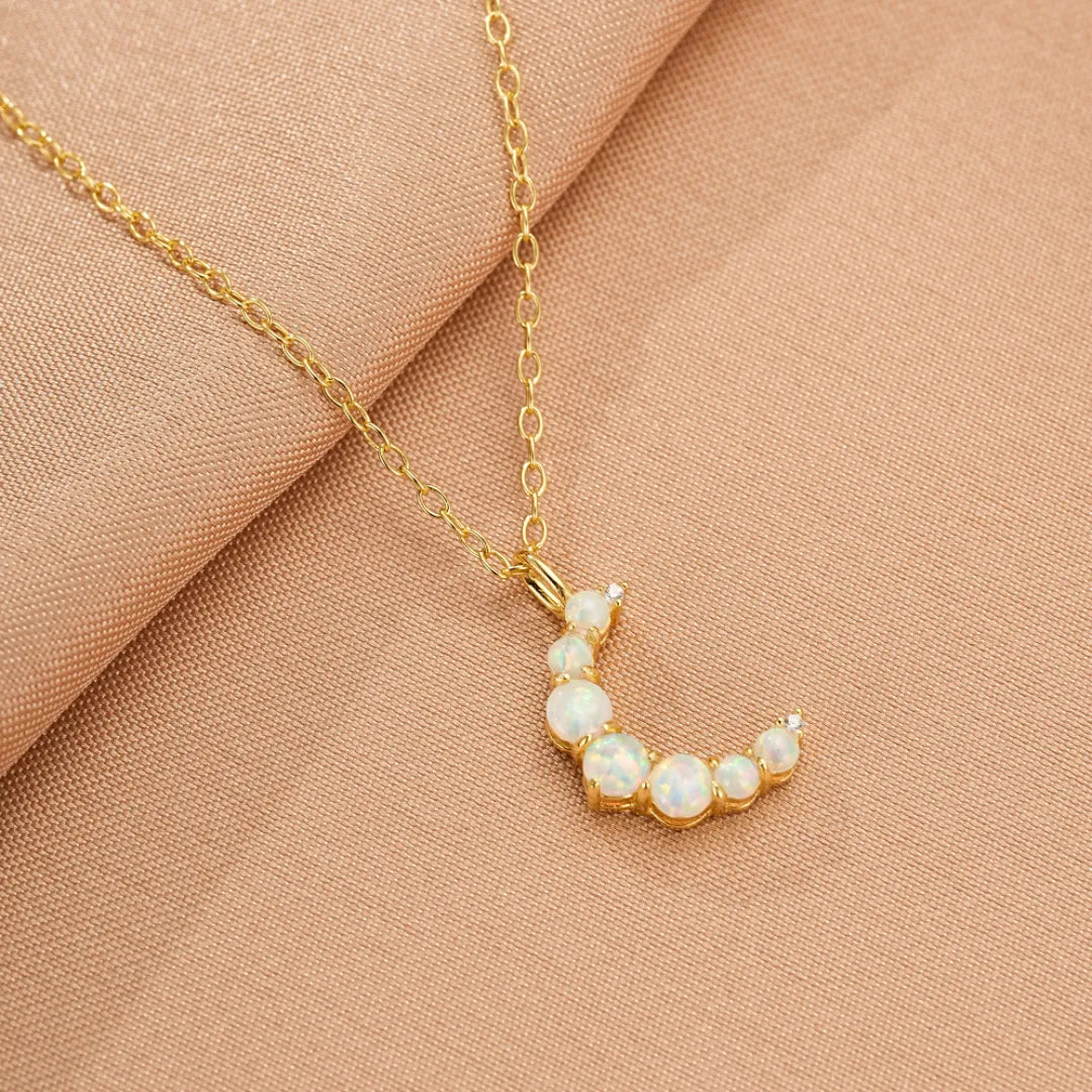 Collier en argent doré à l'or 18 carats avec un pendentif en forme de croissant de lune serti d'opales blanches étincelantes.