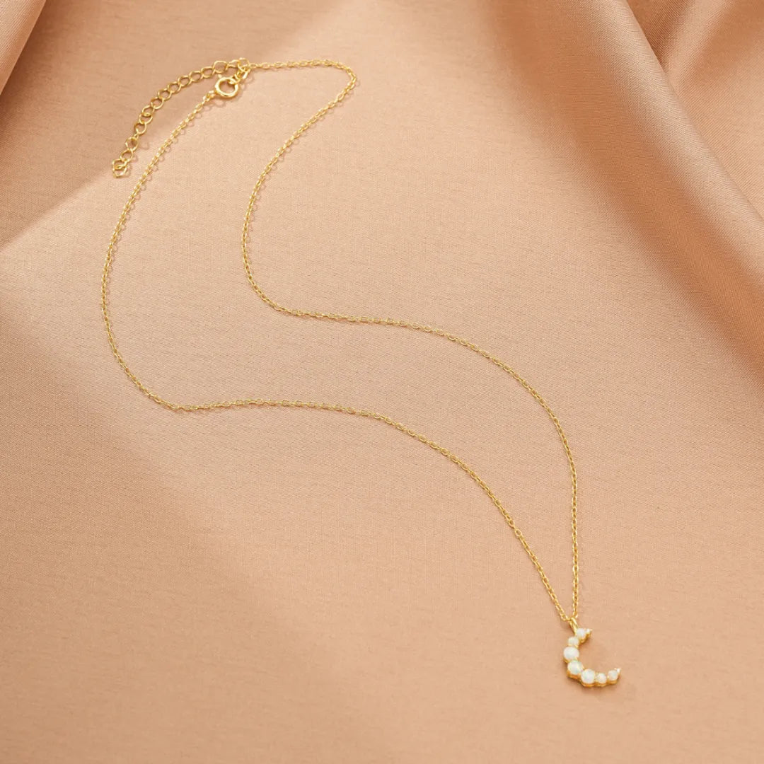 Collier fin en argent doré à l'or 18 carats avec un pendentif en forme de croissant de lune orné de petites opales.