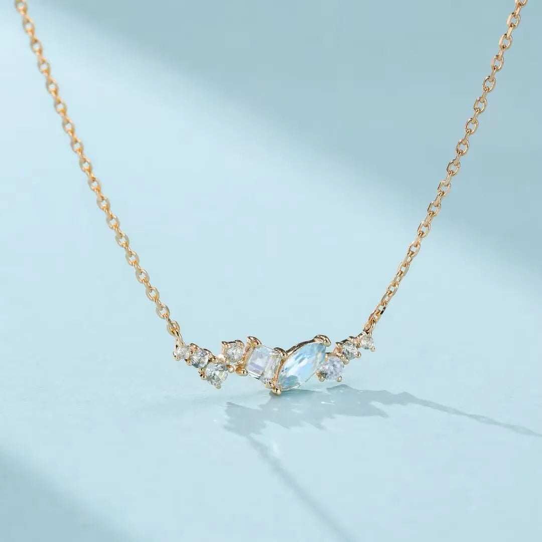 Collier en argent 925 doré à l'or 14K, orné de topazes bleues et de cristaux sertis en forme d'arc.