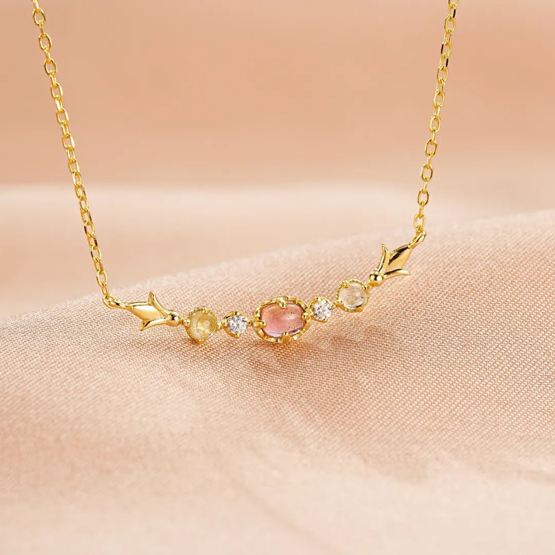 Collier en argent doré 18K, orné de pierres semi-précieuses : tourmaline rose centrale, topazes jaunes et péridots, avec des éclats de zircon blanc. Un bijou délicat et coloré, nommé 'Douceur Éclatante'.