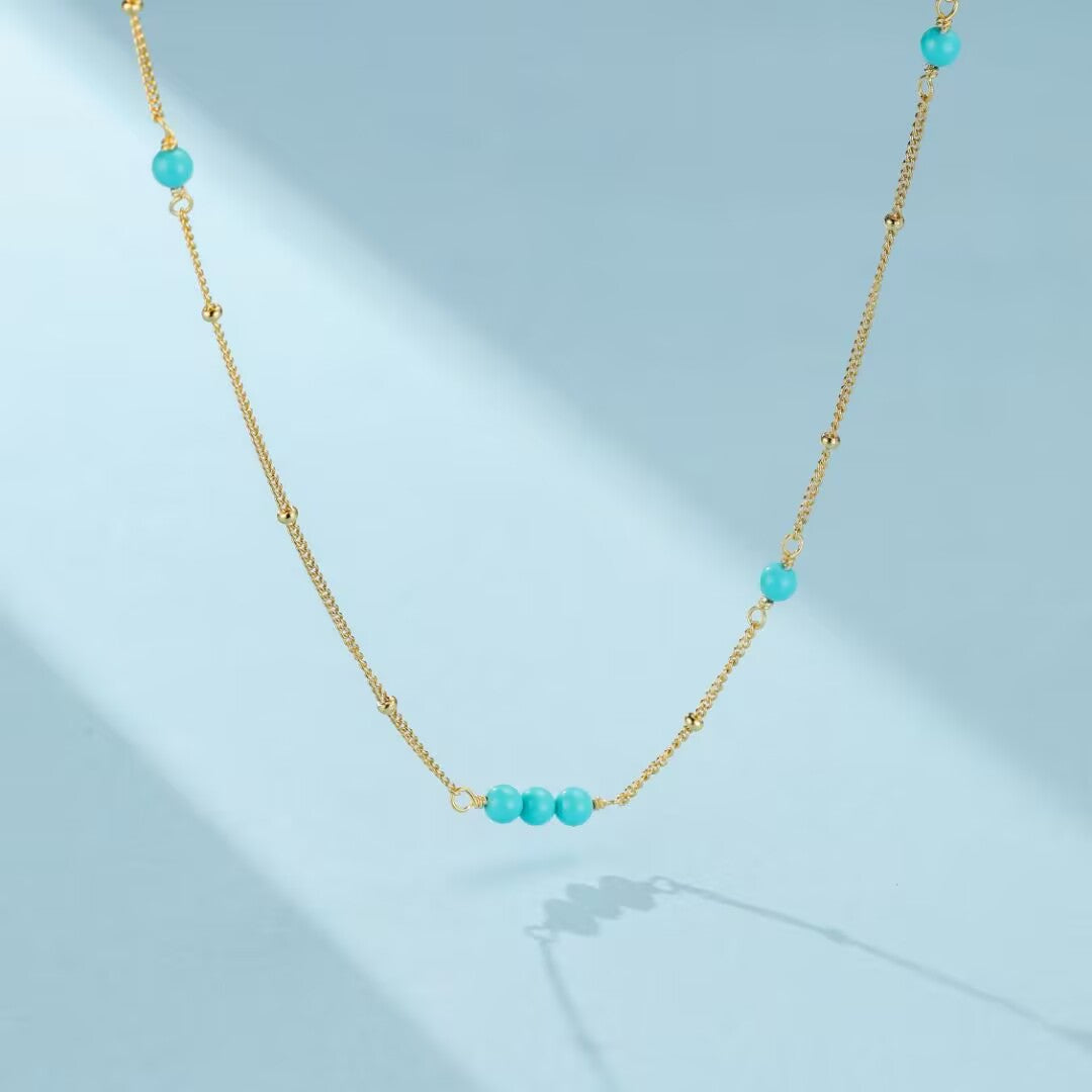 Collier "Dunes de Charme" en argent doré à l'or, orné de perles turquoise naturelles et de petites perles dorées sur une chaîne délicate.