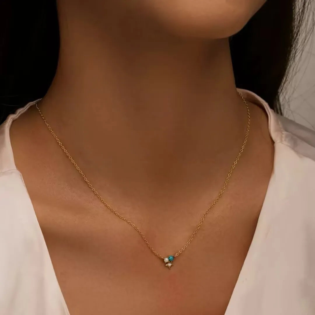 Collier "Sagesse Stellaire" en argent doré or, orné d'une turquoise et de perles, porté par une femme.