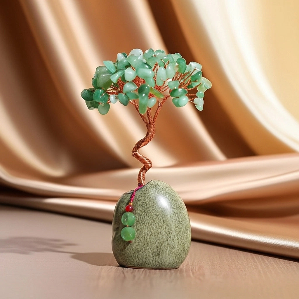 Arbre de vie décoratif en aventurine verte avec des perles suspendues à sa base en pierre.