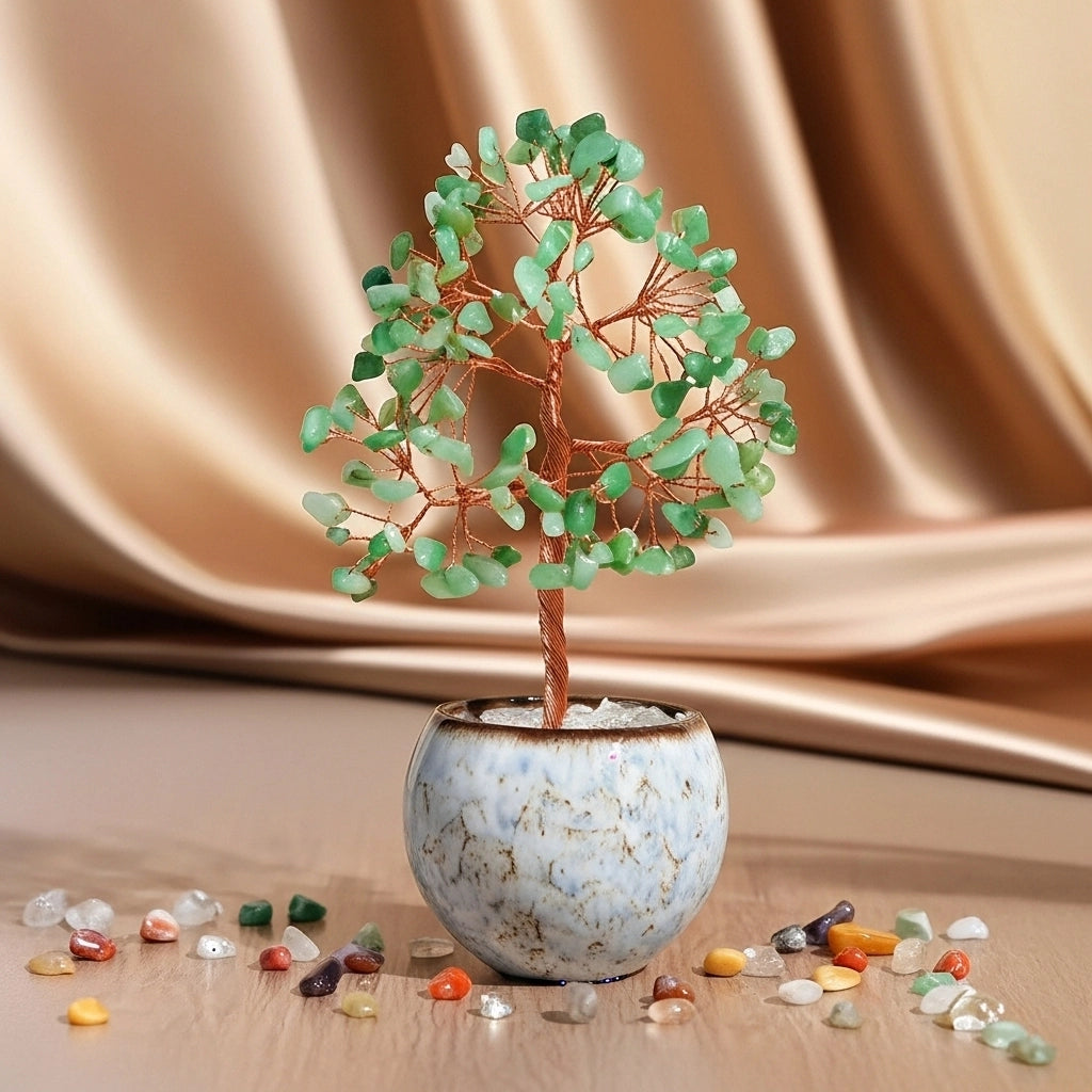 Arbre de vie décoratif en aventurine verte avec un bracelet assorti, présenté dans un pot en céramique, avec des cristaux dispersés autour.