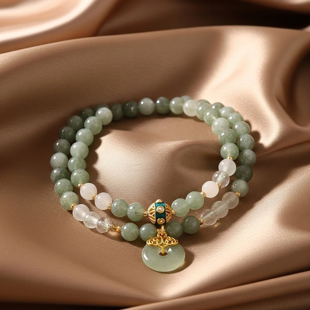 Bracelet double rang en aventurine verte et quartz blanc, orné d'un pendentif rond ajouré et d'un fermoir doré avec détails bleus.