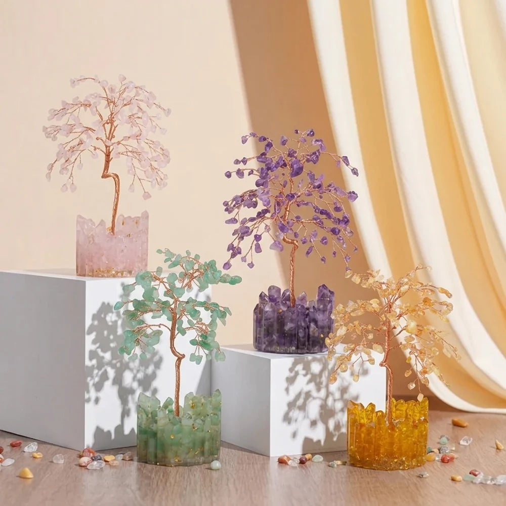 Ensemble de quatre arbres de vie décoratifs en pierres naturelles, aux couleurs rose, violet, vert et jaune, sur des socles en cristal.