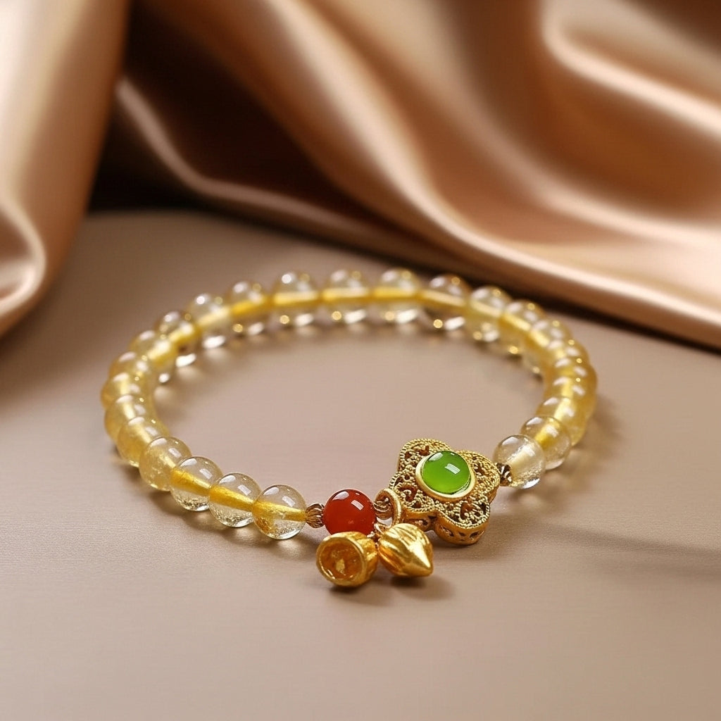 Bracelet Fortune en citrine naturelle avec breloques Arbre de Vie, clochettes dorées et perle rouge.